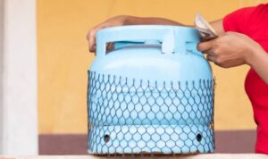 woman holding money and lifting a gas cylinder