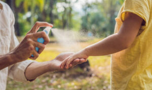 dad and son use mosquito spray.Spraying insect repellent on skin outdoor.